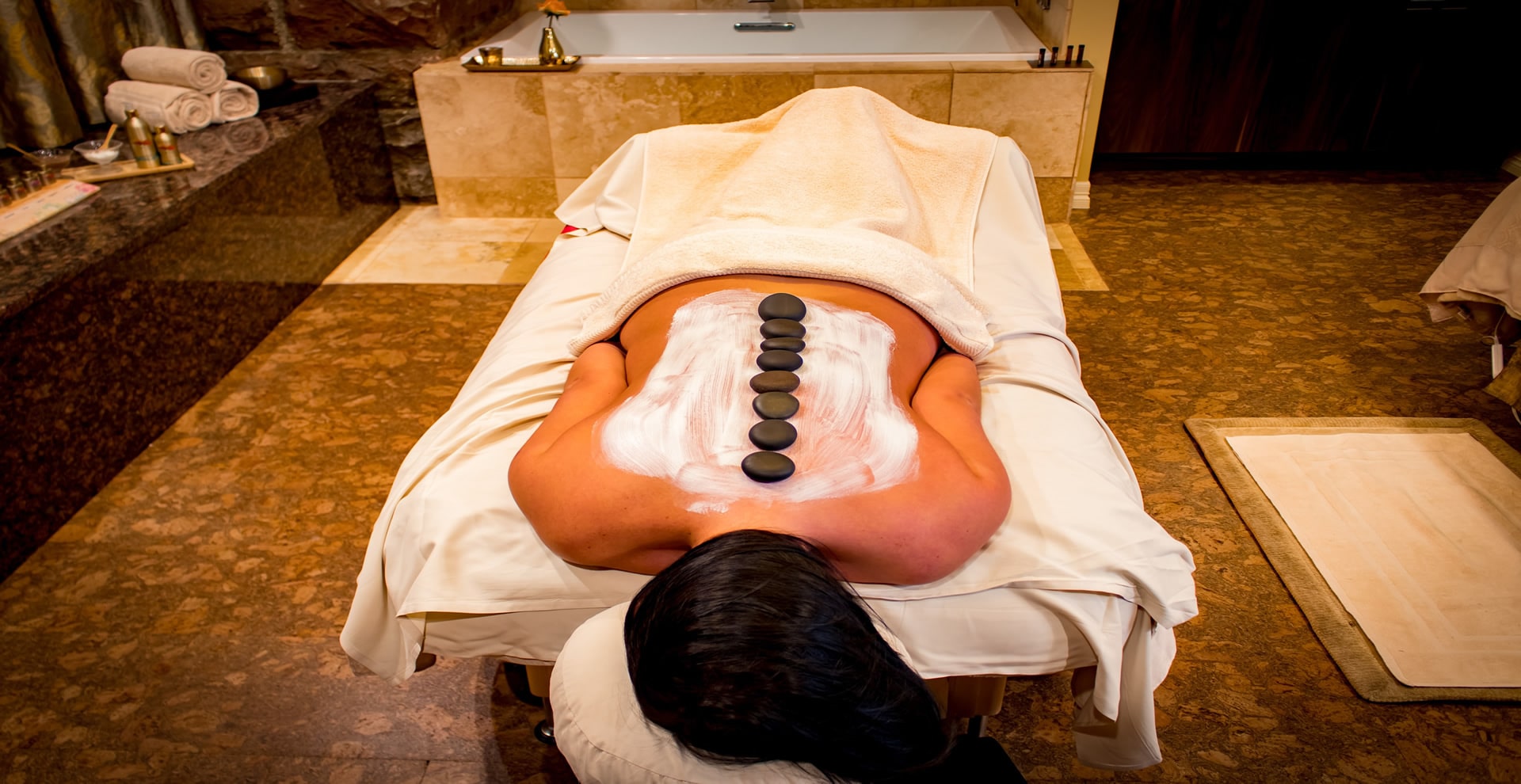 body kneads massage using hot stones